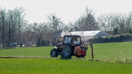 A tractor plowing a lush green field, agricultural growth, spring farming season, sustainable agriculture