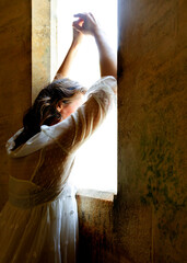 A young woman is gazing out of the window.