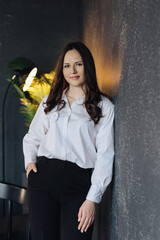 Portrait of a beautiful woman, business lady near the wall