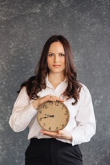 Young businesswoman holding a clock, symbolizing time management and productivity