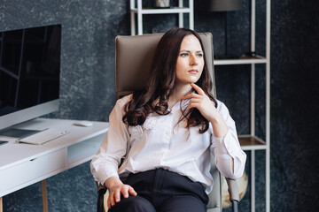 Confident businesswoman sitting in office chair, thinking about strategy and decisions