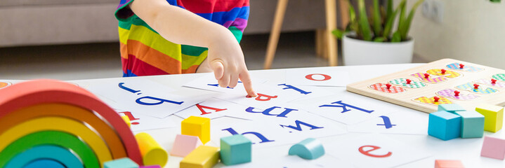 Child learns numbers and letters. Selective focus.
