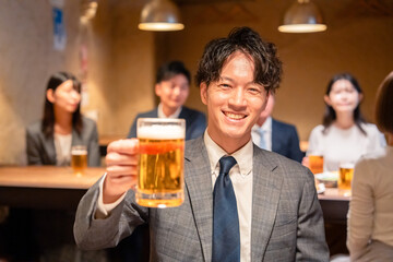 居酒屋でビールの乾杯をするサラリーマンの男性