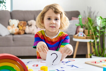 Question mark in the hands of a child. Selective focus.