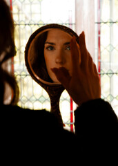 A reflection of a young woman in a mirror © Marcos