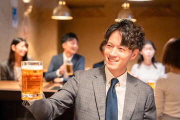 居酒屋でビールの乾杯をするサラリーマンの男性