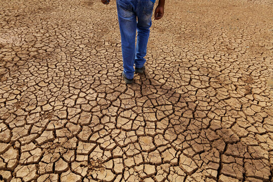 Man walks in the cracked ground of an empty water reservoir dam during a severe drought in Sao Paulo, Brazil.