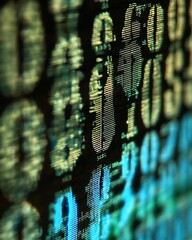 Close - up of blurry binary code on a screen, representing digital information and computer language.