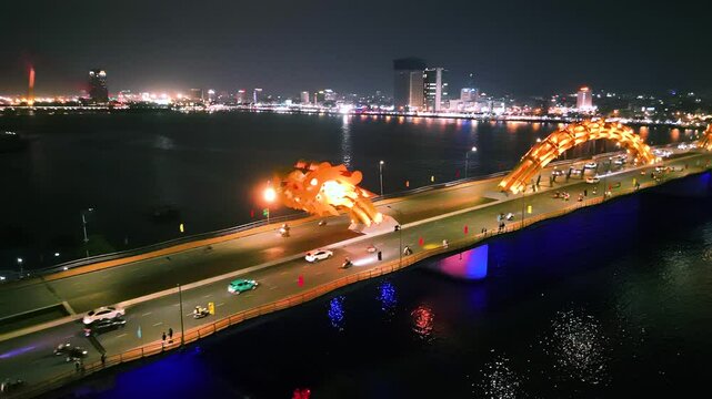 Fiery dragon bridge illuminating nighttime da nang skyline, casting vibrant reflections across han river waters, highlighting architectural marvel in central vietnam