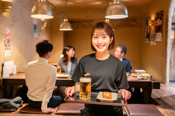 居酒屋のホールで働く若い女性