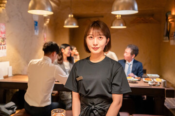 Obraz premium 居酒屋のホールで働く若い女性