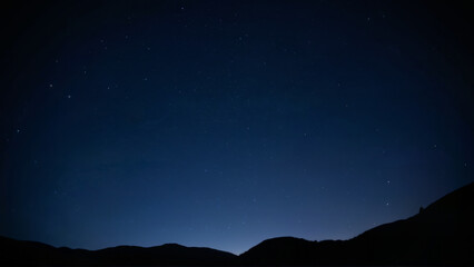 Starlit Sky Over Mountain Silhouettes at Dusk
