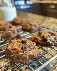 Fototapeta premium Vegan chocolate chip cookies cooling on a wire rack, with almond milk in the background