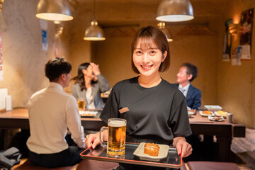 居酒屋のホールで働く若い女性