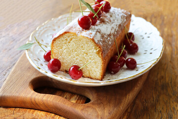Sponge cake with cherry on old wooden background. Biscuit with summer fruit 