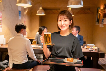 居酒屋のホールで働く若い女性