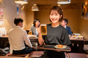 居酒屋のホールで働く若い女性