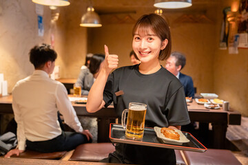 居酒屋のホールで働く若い女性