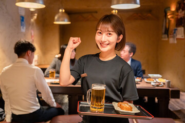 居酒屋のホールで働く若い女性