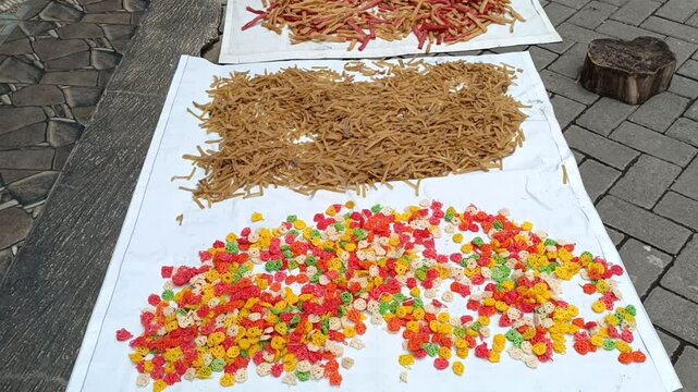 Raw Unfried Crackers Drying on White Trays Under Sunlight for Traditional Food Production