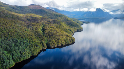 Dark lakes between the mountains of Tasmania on a cloudy day, seen from above