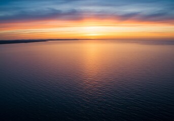 Fototapeta premium 穏やかな夕焼け、水平線に広がる静かな海、優しい光彩