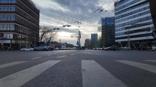 Time-lapse of urban traffic and pedestrians at sunset with bus and tram motion