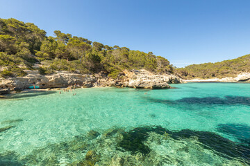The picturesquely beautiful coast of the island of Menorca and the beach of Cala Mitjana Azure water, clear water of the Mediterranean Sea. The holiday landscape of Spain