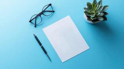 Fototapeta premium Blank Paper Mockup Elegant Workspace with Pen Glasses and Succulent Plant on Blue Background