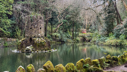 Ancient stone tower in lush forest by tranquil pond, perfect for nature retreats, mystical escapes...