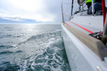 A Sailing Yacht racing and moving quickly throuhg the water, sailing in the atmospheric conditions of the English Channel.
