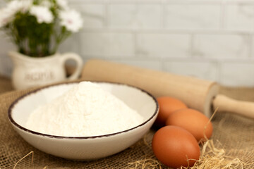 Baking products - flour, eggs. Flour and eggs on the table close-up