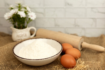 Baking products - flour, eggs. Flour and eggs on the table close-up