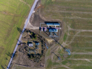 defaultAerial view of a substation captured from a 90-degree top-down shot, showcasing the layout of electrical transformers, power lines, and the surrounding infrastructure.