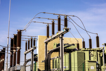 A close-up shot of a substation showing power lines, transformers, and electrical cables, highlighting the complexity of the energy infrastructure.