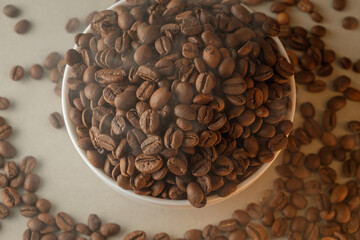 Rich brown coffee beans fill a white bowl with aromatic steam rising
