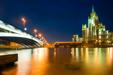 Obraz premium A high-rise building on Kotelnicheskaya embankment and Bolshoy Ustinsky bridge at night. Moscow