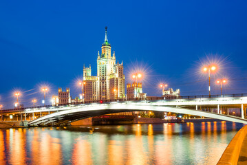Fototapeta premium A high-rise building on Kotelnicheskaya embankment and Bolshoy Ustinsky bridge at night. Moscow