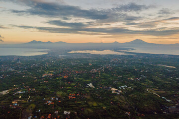 Drone view of Bukit peninsula with with a view of Denpasar and volcanoes in Bali.