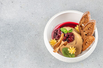 duck liver pate with cherries and toasted bread slices on a light background, top view. copy space