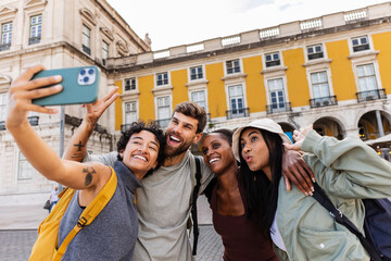 Obraz premium Happy tourists taking selfie in lisbon, portugal, with smartphone