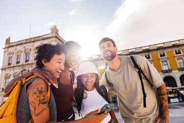 Tourists using phone and laughing in lisbon, portugal