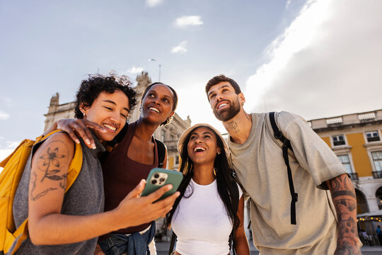 Happy tourists using smartphone and enjoying lisbon vacation - Powered by Adobe