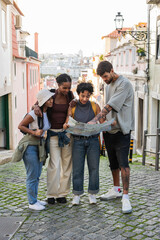 Obraz premium Group of tourists reading a map in lisbon, portugal