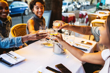 Friends toasting drinks at outdoor restaurant table