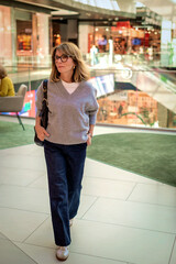 Full length of mid aged woman walking in a shopping mall