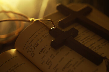 Wooden Crosses on Open Book with Warm Light - Symbol of Religion, Faith, and Spirituality