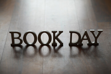 Book Day Concept with Wooden Letters on Rustic Wooden Surface for Reading Enthusiasts and...