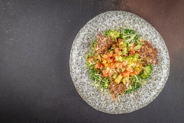 Delicious avocado and raw salmon salad, tartare. on a dark background. top view. copy space for text