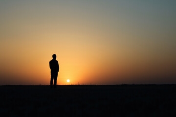 Fototapeta premium Silhouette of praying person in golden light